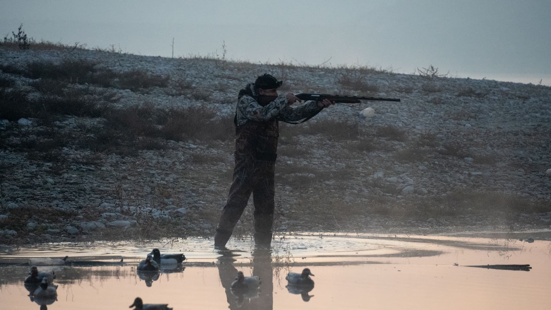 A hunter glassing a ridgeline at first light on public land