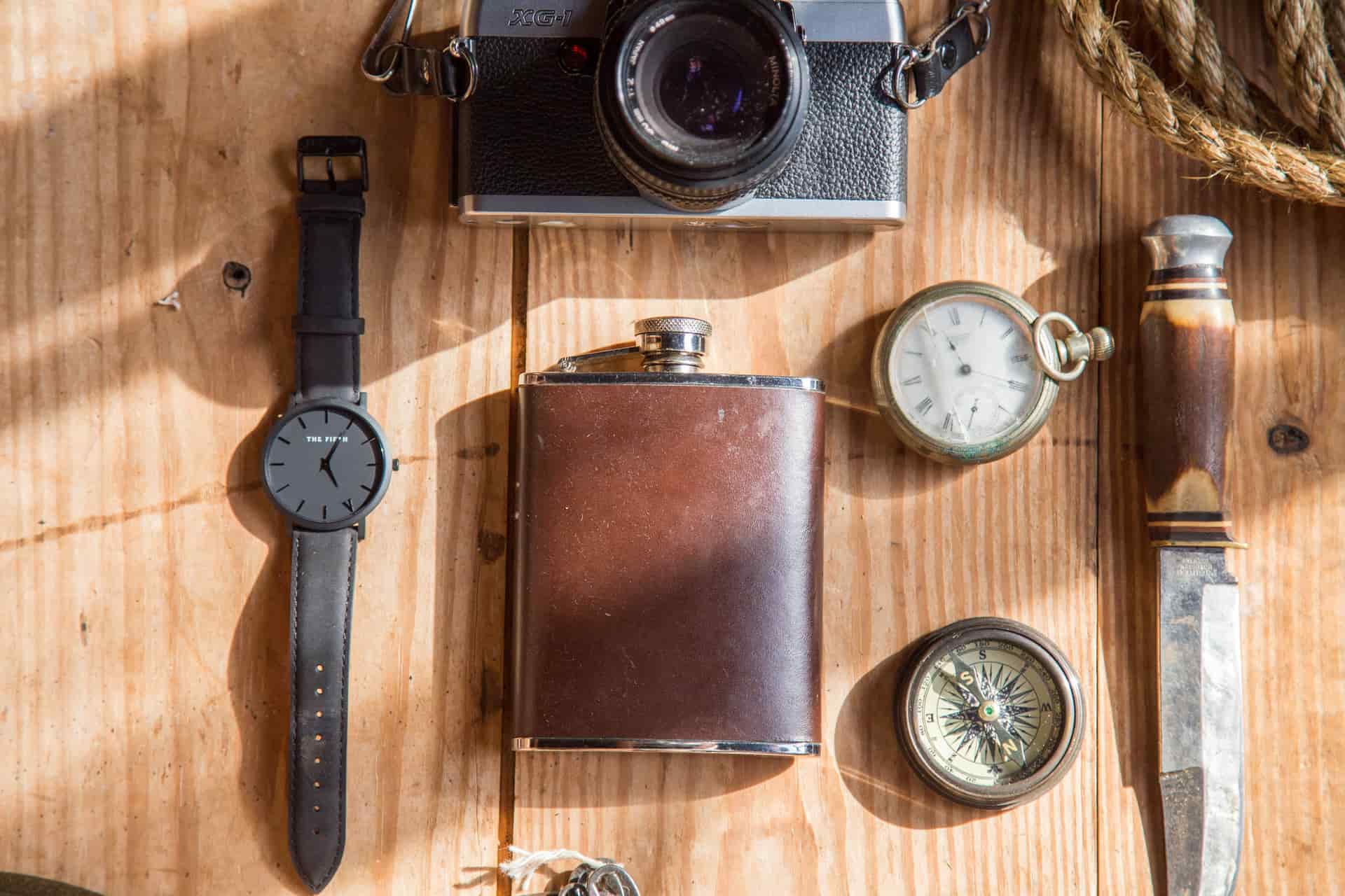 Hunting gear and a knife laid out on a wood surface