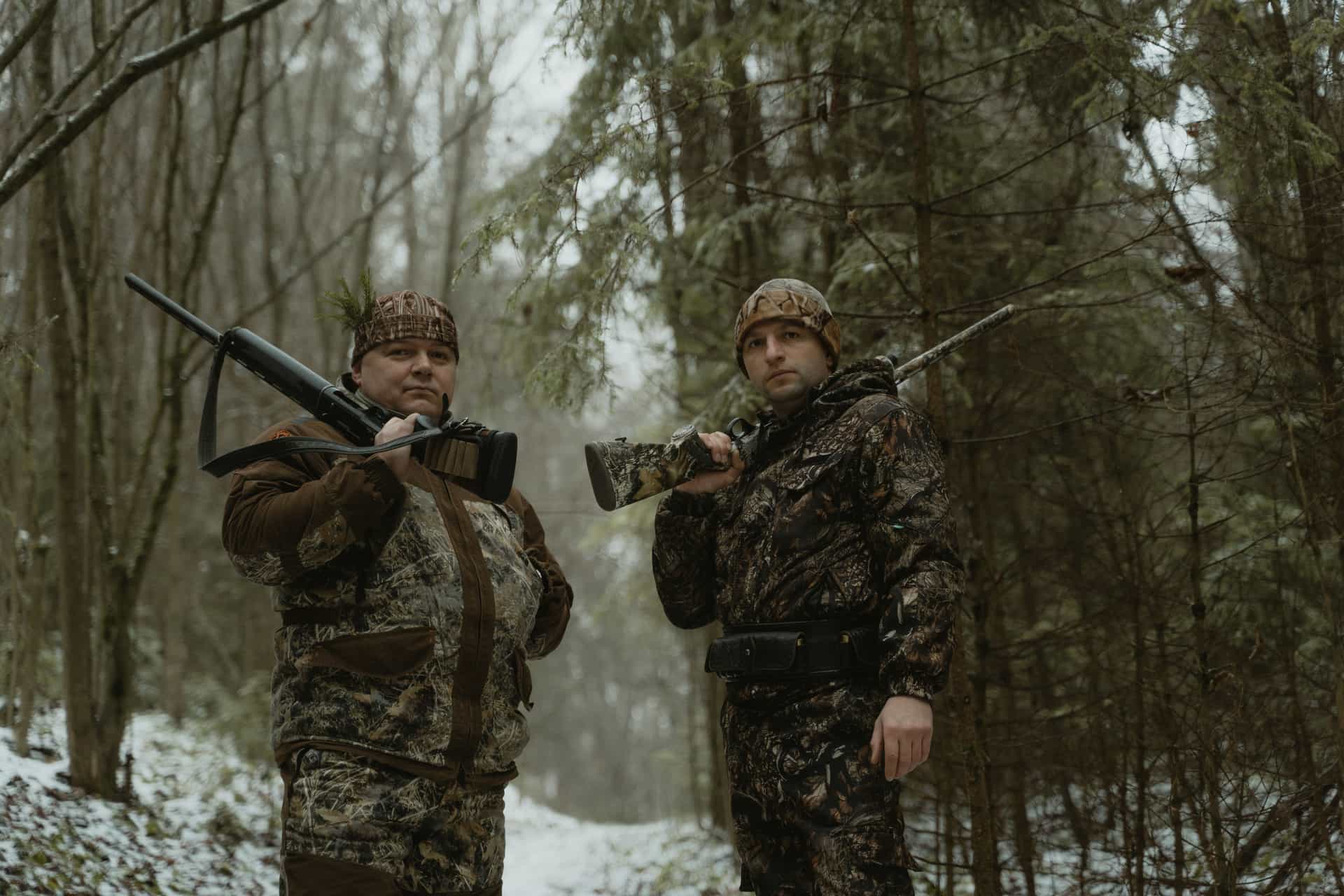 A hunter in camo layers against autumn timber